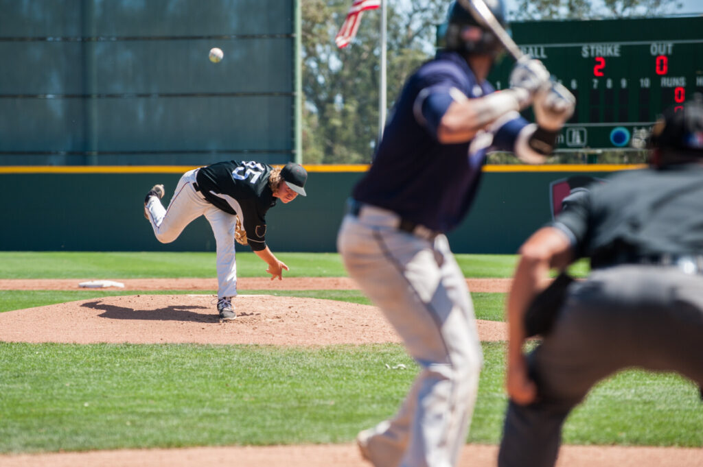 Young baseball player throwing ball to a batter
